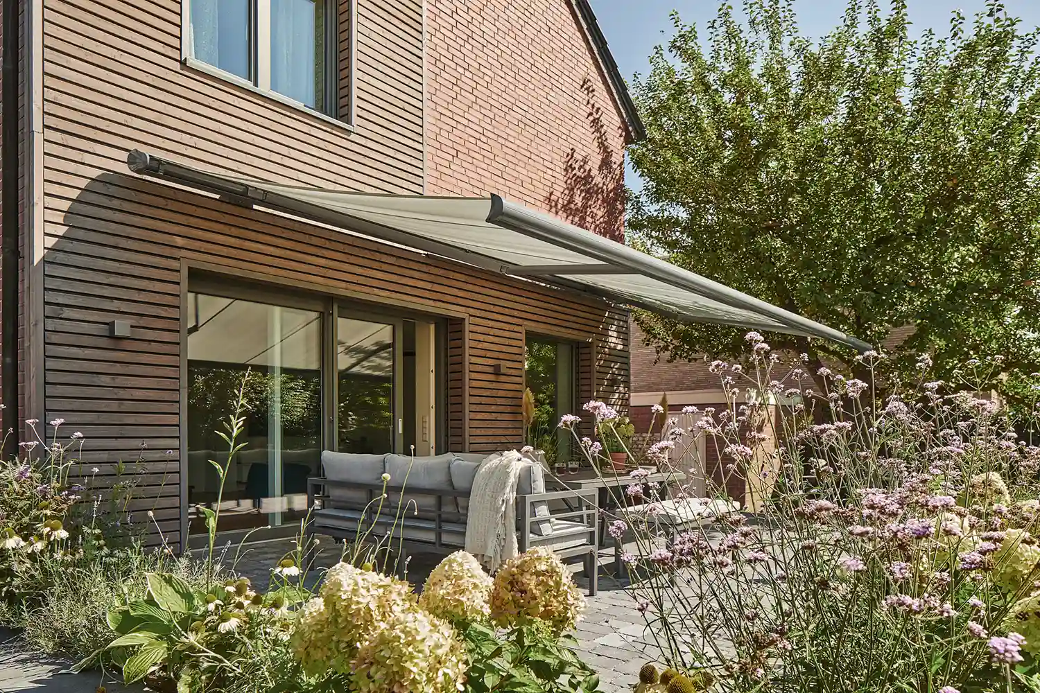 Moderne Terrasse mit Gartenmöbeln und Markise