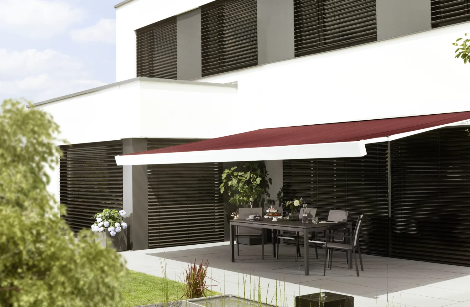 Moderne Terrasse mit Sonnenschutz und stilvollen Gartenmöbeln