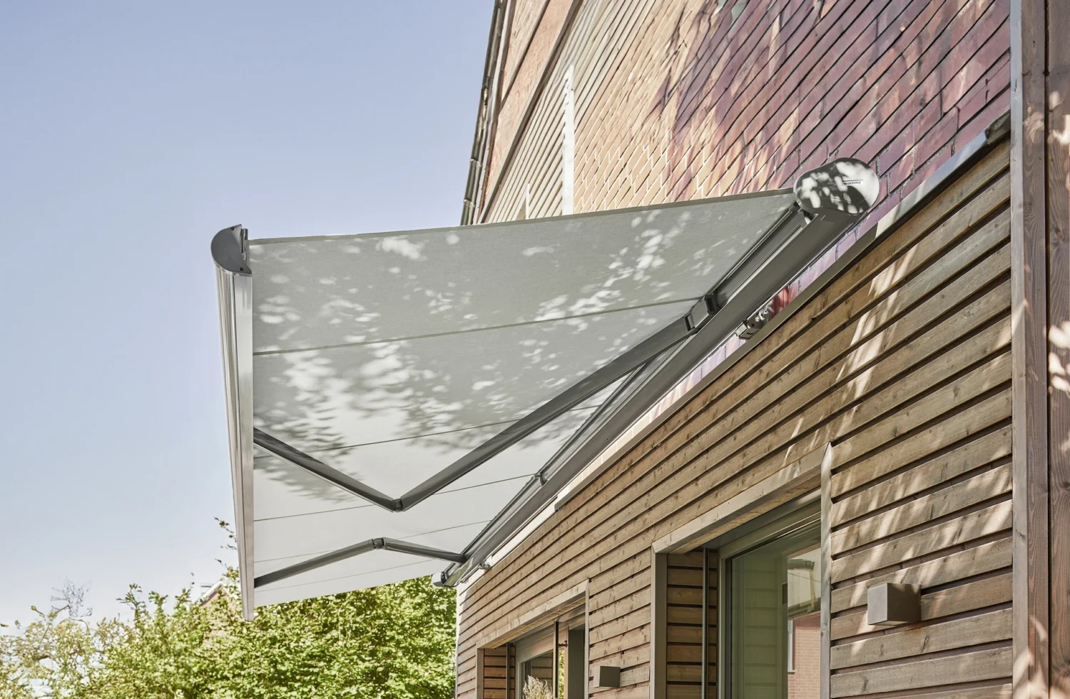 Moderne Markise an einem Holzhaus bei Sonnenschein